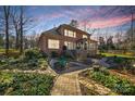 Landscaped backyard with brick paver pathway and a deck at 12710 Winding Ridge Rd, Huntersville, NC 28078