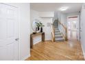 Inviting entryway with wood floors, stairs and a decorative table with round mirror at 2151 Belle Vernon Ave, Charlotte, NC 28210