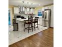 Open kitchen featuring a center island, white cabinets, stainless steel appliances, and hardwood flooring at 217 Ruby Ln, Gastonia, NC 28054