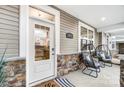 Inviting front entry with glass door and modern chairs on the porch at 4008 Cheyney Park Dr, Charlotte, NC 28269