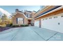 Lovely brick home with a three-car garage, surrounded by a pristine concrete driveway and lush landscaping at 407 Blue Bay Ct, York, SC 29745