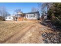 Gray siding house with brick base, wooden porch, and gravel driveway at 604 Kimball St, Kannapolis, NC 28081