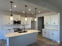 Modern kitchen featuring white cabinets, a center island with seating, and stainless steel appliances at 6327 Honor Ave, Midland, NC 28107