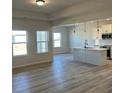 Open-concept kitchen with white cabinets, stainless steel appliances, and hardwood floors at 6327 Honor Ave, Midland, NC 28107