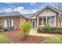 Brick home with sunroom and landscaped front yard at 8355 Olde Troon Dr, Charlotte, NC 28277