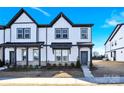 Two-story townhome with white and gray exterior, landscaping, and walkway at 9131 Nw Harwen Ne Ln # 32, Charlotte, NC 28215