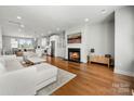 Open concept living area with fireplace and hardwood floors at 11936 Fiddlers Roof Ln, Charlotte, NC 28277