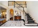 Grand foyer with marble floors, staircase, and elegant console table creating a lasting first impression at 12201 Pine Valley Club Dr, Charlotte, NC 28277