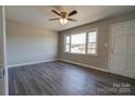 Living room featuring gray walls, wood-look floors, and a large window at 1691 Montevista Dr, Shelby, NC 28150