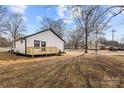 White house with gray roof, wooden deck, and backyard view at 19601 S Ferry St, Cornelius, NC 28031