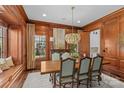 Formal dining room with wood paneling, chandelier, and built-in window seat at 303 Hillside Ave, Charlotte, NC 28209