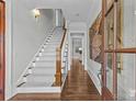 Bright entry with hardwood floors, a staircase, and artwork at 303 Hillside Ave, Charlotte, NC 28209