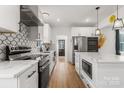 Modern white kitchen with stainless steel appliances and marble countertops at 303 S Greene St, Wadesboro, NC 28170