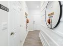 Hallway with white trim and plank flooring, featuring hooks and a round mirror at 3148 Ora Smith Rd, Lincolnton, NC 28092