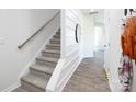 A modern staircase with carpeted steps, a wooden handrail, and a view into an adjacent hallway at 3148 Ora Smith Rd, Lincolnton, NC 28092