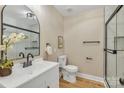 Well-lit bathroom featuring a glass door shower, white vanity, sleek fixtures, and a modern design at 407 Thomas St, Marshville, NC 28103