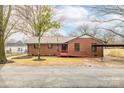 Charming brick home featuring a well-maintained lawn and a convenient carport at 407 Thomas St, Marshville, NC 28103