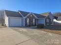 Charming single-story home featuring a brick facade, attached garage, and a concrete driveway at 4630 Sw Falcon Chase Sw Dr, Concord, NC 28027