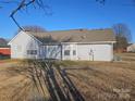 Backyard view of a house with light gray siding and double doors leading to a lawn at 4630 Sw Falcon Chase Sw Dr, Concord, NC 28027