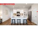 Modern kitchen with white cabinets, island, and stainless steel appliances at 553 Zermatt Ct, Monroe, NC 28112