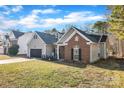 Low angle of the house showing the garage, partial brick, and front lawn at 12527 Cedar Post Ln, Charlotte, NC 28215