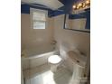 Clean bathroom with a tub, toilet and pedestal sink at 1814 Logie Ave, Charlotte, NC 28205