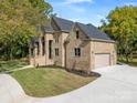 Two-story brick home with a three-car garage and landscaped lawn at 209 E Glenview Dr, Salisbury, NC 28147