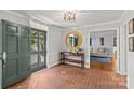 Entryway with brick flooring, green door, and a large round mirror at 2228 Valencia Ter, Charlotte, NC 28226