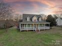 Two-story house with a wraparound porch, and a landscaped yard at 2400 Potter Downs Dr, Waxhaw, NC 28173