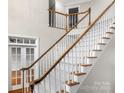 Elegant staircase with wooden railing and carpet at 5972 Rathlin Nw Ct, Concord, NC 28027