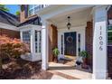 Inviting front entryway with a wreath on the door, decorative plants, and elegant architectural details at 11006 Knight Castle Dr, Charlotte, NC 28277