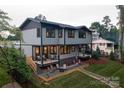 Backyard with deck, seating area and fire pit, landscaped with gravel and grass at 113 Angler Pl, Mooresville, NC 28117