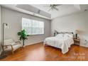 Bright primary bedroom with tray ceiling, hardwood floors, and a large window at 13922 Pilcher Dr, Charlotte, NC 28278