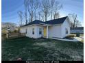 Front view of a small home with a yellow door and small yard at 4470 Kingsbury Rd, Midland, NC 28107