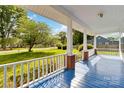Inviting front porch with a blue painted floor and white railings at 6037 Pleasant Grove Rd, Charlotte, NC 28216