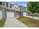 Exterior of townhome with front door, garage, and landscaping at 7011 Jane Parks Way, Charlotte, NC 28217