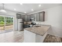 Modern kitchen with gray cabinets, granite counters, and stainless steel appliances at 7011 Jane Parks Way, Charlotte, NC 28217