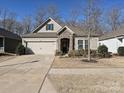 Charming home featuring stone accents, a two-car garage, and a well-manicured front yard at 7522 Porrera St, Charlotte, NC 28214