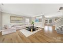 Bright living room with hardwood floors, comfortable sectional sofa, and a clear view of the adjacent den at 10319 Barrands Ln, Charlotte, NC 28278