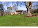 Traditional two-story brick home with a lush green lawn and mature trees at 107 Cambridge Rd, Huntersville, NC 28078