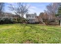 Expansive backyard featuring a well-maintained lawn, mature trees, and a wooden deck on the home's rear at 212 Catalina Dr, Mooresville, NC 28117