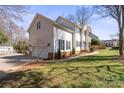 View of home's side exterior featuring white siding, black shutters, a two-car garage, and manicured lawn at 212 Catalina Dr, Mooresville, NC 28117