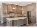 Spacious kitchen with gray cabinets, granite counters, and brick backsplash at 304 Tradition Dr, Mount Gilead, NC 27306