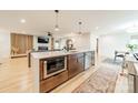 Open-concept kitchen featuring an island with stainless steel appliances and views of the living area at 531 Manhasset Rd, Charlotte, NC 28209