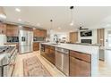 Modern kitchen with stainless steel appliances and light hardwood floors open to the living area at 531 Manhasset Rd, Charlotte, NC 28209