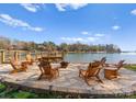 Outdoor patio area features Adirondack chairs with lake view at 125 Chestnut Tree Rd, Mooresville, NC 28117