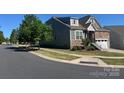 A two-story house with green and brown panels and landscaping on a sunny day at 1605 Appledale Ct # 116, Fort Mill, SC 29715