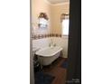 Bathroom with clawfoot tub and patterned border at 1724 Lowder St, Albemarle, NC 28001