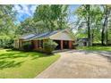 View of the home's brick facade featuring an attached garage with a driveway and an outbuilding at 1801 Windsor Dr, Lancaster, SC 29720