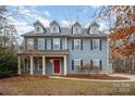 Two-story house with gray siding, red door, and landscaping at 2101 Darian Way, Waxhaw, NC 28173